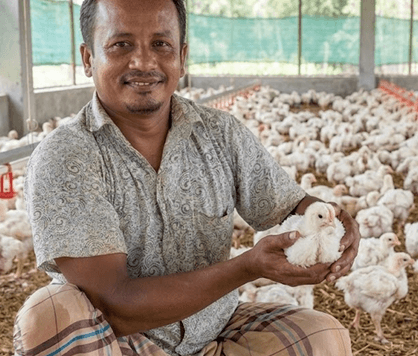Farmer managing a poultry shed with smart controls